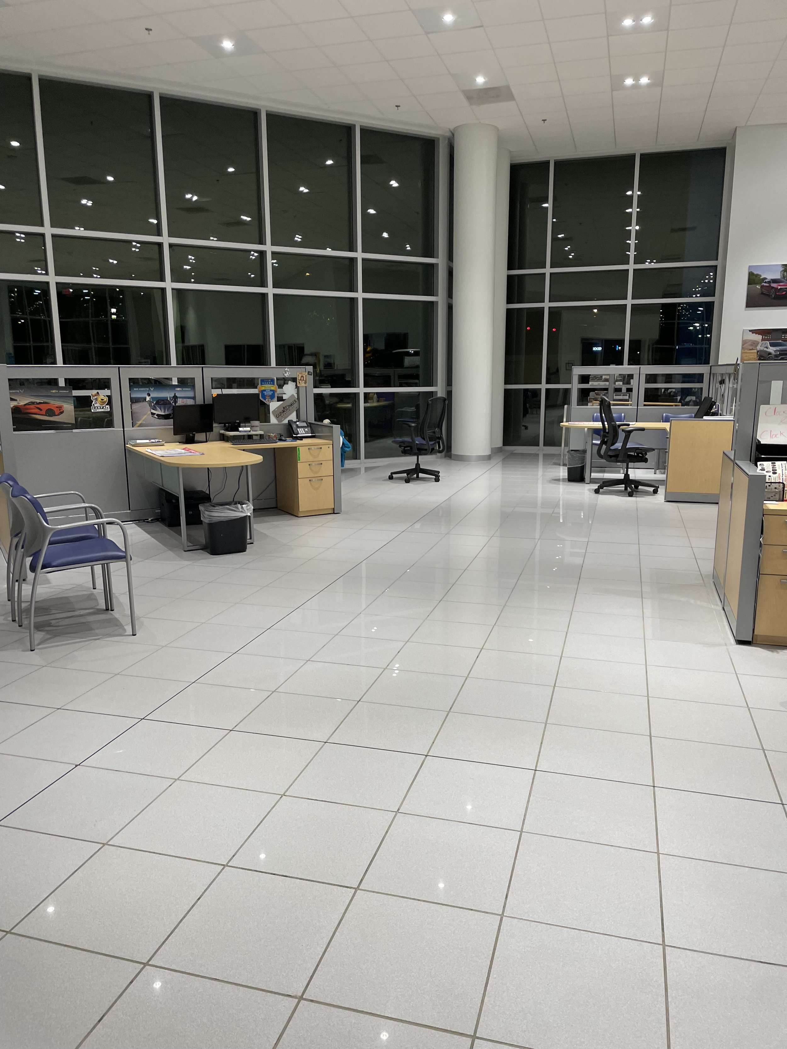 High-gloss polished automotive dealership showroom floor reflecting ambient light